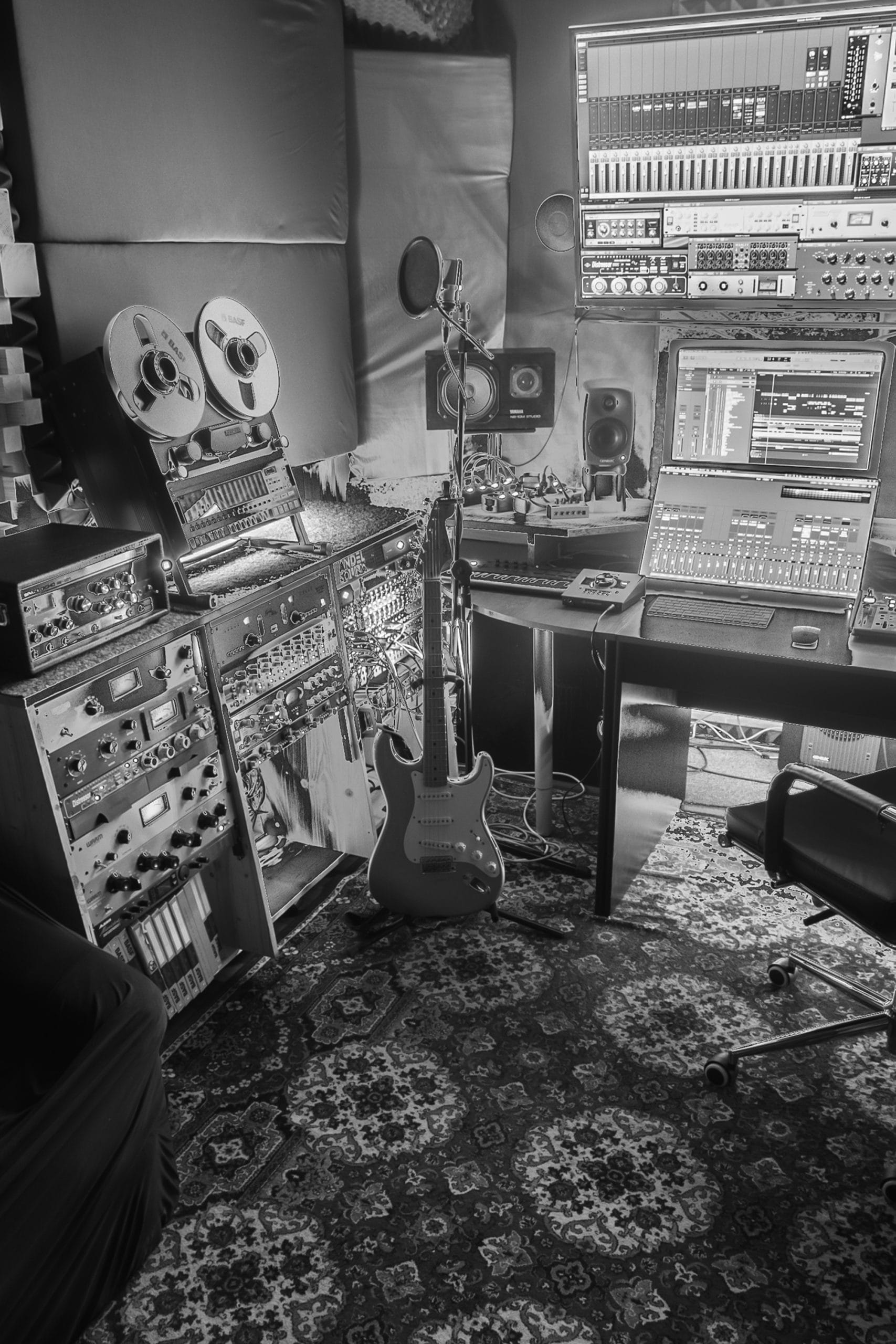 Andel Sound's recording studio, with a mixing desk, reel-to-reel tape deck, and an electric guitar on a stand.